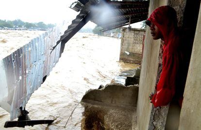Un hombre observa desde su casa un río desbordado en Puerto Príncipe, Haití.