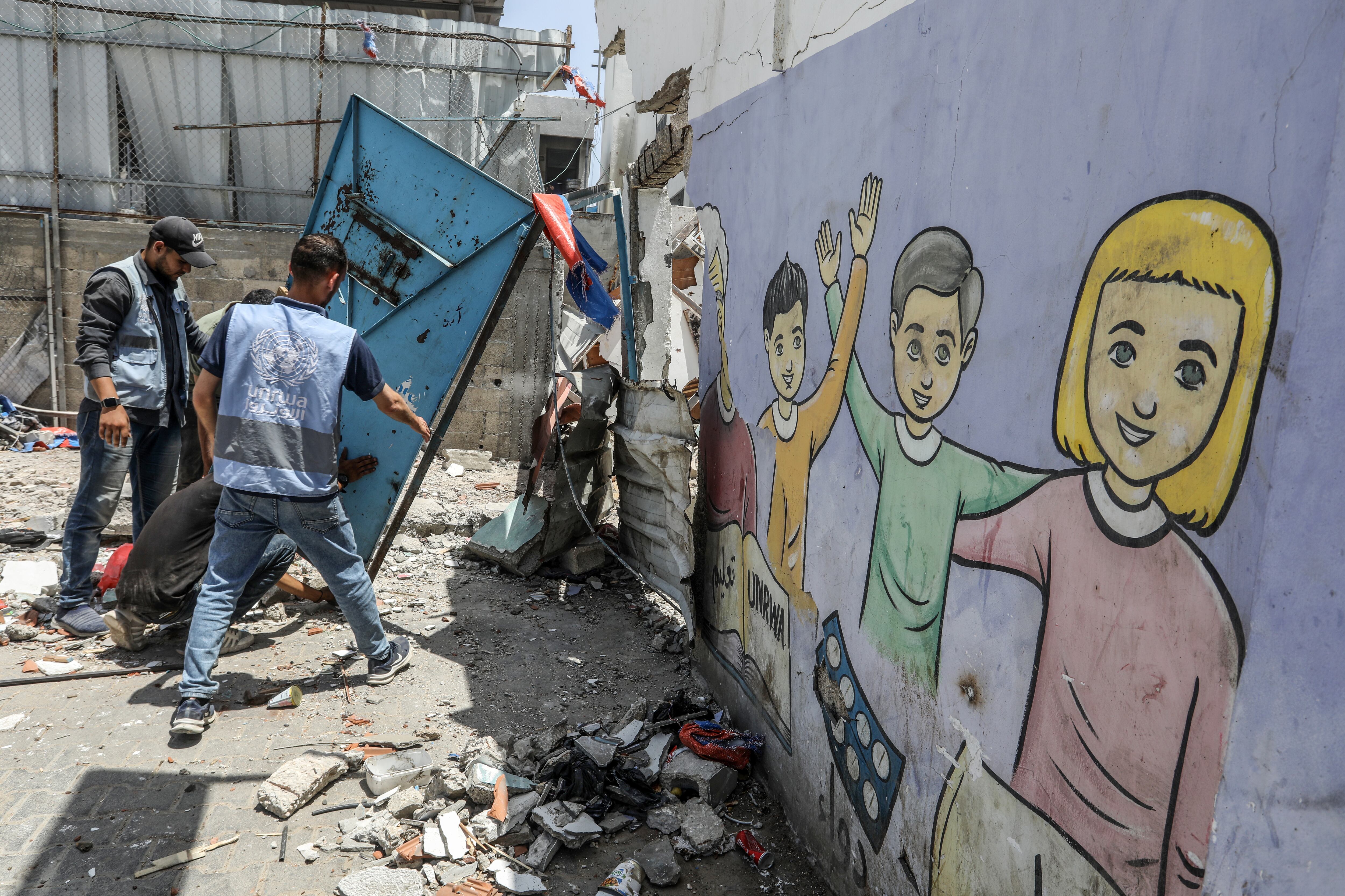 DEIR AL BALAH, GAZA - MAY 26: Workers of UNRWA (United Nations Relief and Works Agency for Palestinian Refugees) inspect the destruction after an attack carried out by Israeli army on a building belonging to the UNRWA located in the Nuseirat Refugee Camp in Deir al-Balah, Gaza on May 26, 2024. (Photo by Abed Rahim Khatib/Anadolu via Getty Images)