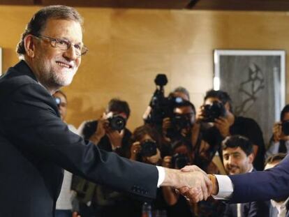 El presidente del Gobierno, Mariano Rajoy (izquierda), estrechando la mano del presidente de Ciudadanos, Albert Rivera, durante una reuni&oacute;n para certificar el acuerdo de investidura.