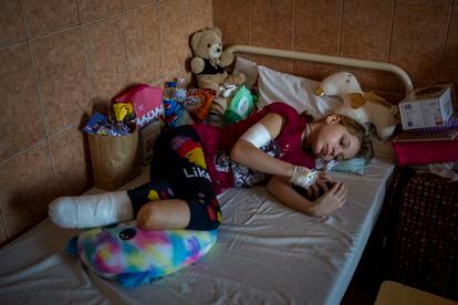 Yana Stepanenko, de 11 años, mira su su móvil en la cama de un hospital público en Lviv, Ucrania, el jueves 12 de mayo de 2022.  