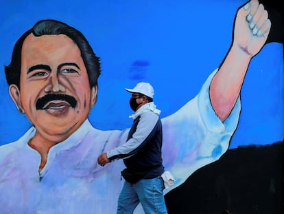 Un hombre camina frente a un mural de Daniel Ortega en Managua.