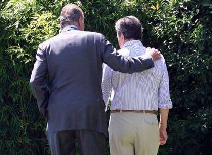 El rey don Juan Carlos pasea junto a Adolfo Suárez por el jardín de la casa del ex presidente.
