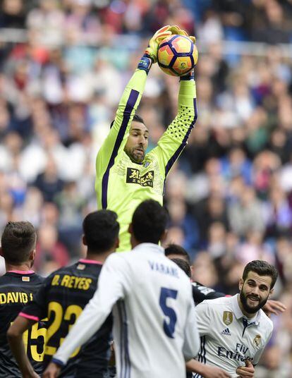 El portero del Espanyol, Diego López, atrapa la pelota ante los jugadores del Real Madrid. 