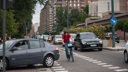 Una mujer con una de las bicis del servicio municipal de préstamo esquiva un coche en el ciclocarril de la avenida Isabel la Católica, en Valladolid.
