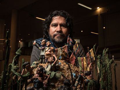 Edgar Álvarez, posa junto a una de sus obras en su exposición sobre migración, en el centro cultural Gabriel García Marquez en Bogotá, Colombia, el 3 de agosto del 2023.