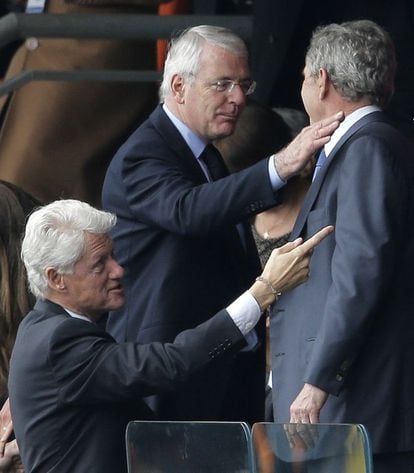 El ex primer ministro británico John Major, centro, saluda a George W. Bush y Bill Clinton.