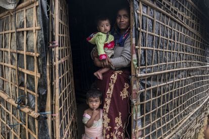 Ransia posa con sus dos hijos en la puerta de su casa en el campo de refugiados
