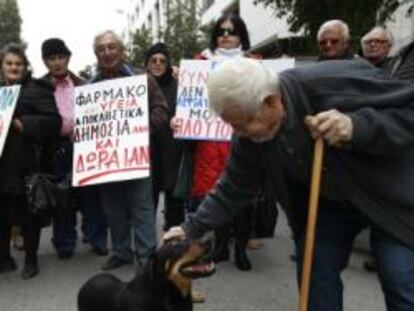 Un pensionista acaricia a un perro en una protesta hoy en Atenas contra las medidas de austeridad aprobadas por el Parlamento.