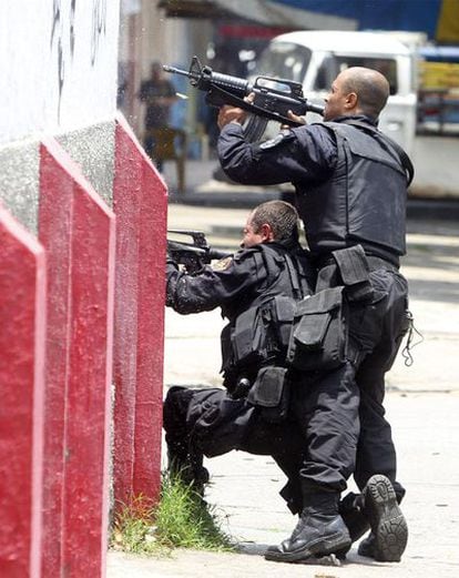 Dos agentes del Batallón de Operaciones Policiales Especiales se apostan en un edificio durante un intercambio de fuego en Vila Cruzeiro.