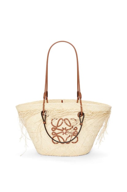 Loewe actualiza el prototipo clásico del capazo en esta versión deshilachada y con un aire bohemio. Un diseño de la colección Paula’s Ibiza fabricado en palma de iraca, un tejido confeccionado por mujeres artesanas en Colombia. 780 euros.