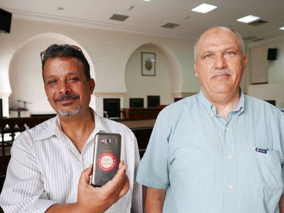 Jamel Baraket, junto al exdiputado Najib Murad, muestra una pegatina en su móvil con el lema: "No al olvido", en Nabeul (Túnez).
