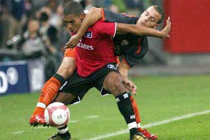Carlos Javier Cuéllar lucha por el balón con el jugador de Hamburgo Nigel de Jong.