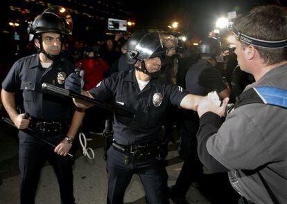 Un polic&iacute;a se enfrenta a un manifestante en Los &Aacute;ngeles.