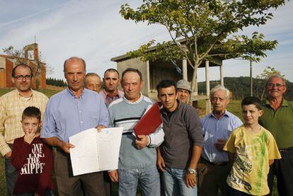 Vecinos de Ribadulla muestran los papeles del terreno que rodea la iglesia.