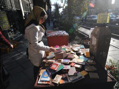 Una iran&iacute; hojea libros en Teher&aacute;n.