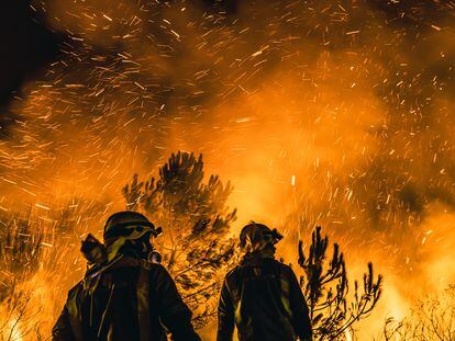 Dos bomberos, ante el fuego declarado en Boiro (A Coruña).