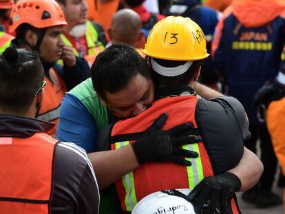 Miembros de un grupo de rescate se abrazan tras sonar la alerta sísmica este sábado en Ciudad de México.