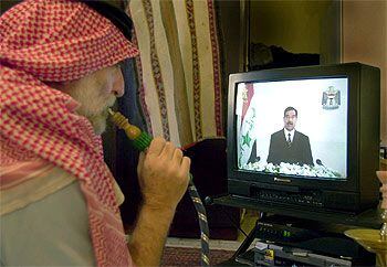 Un kuwaití sigue el discurso de Sadam en el canal nacional iraquí, en su casa de Kuwait.