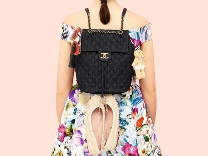 Minimochila con solapa superior y cierre dorado de Chanel. En los laterales, pompón de cuero azul de Swarovski, gafas en pasta roja de Dolce & Gabbana, llavero de osita de Airfield y bailarinas con bordado de flores de Pretty Ballerinas. El vestido de seda estampada es de Coosy. 