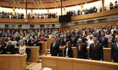 Los diputados asistentes al pleno guardan en pie un minuto de silencio al inicio de la sesión, en recuerdo de las víctimas del accidente de tren de Santiago de Compostela.