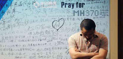 Un hombre frente a un panel con mensajes de apoyo a las v&iacute;ctimas del MH370.
 