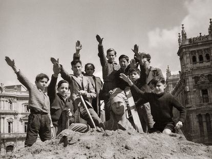 Niños saludando con el brazo en alto durante las obras de desescombro de la Cibeles en 1939, en una imagen del Fondo Martín Santos Yubero.