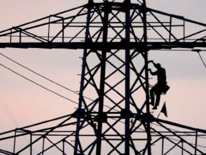 Un operario repara una torreta eléctrica. 