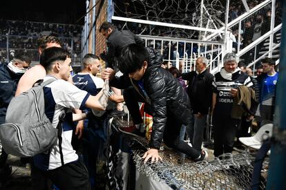 Varias personas ayudan a salir de las gradas a un grupo de aficionados, en el estadio de la ciudad de La Plata. Un fotógrafo fue herido por las balas de goma y al menos un centenar de espectadores fueron llevados a hospitales de la zona tras los incidentes. 