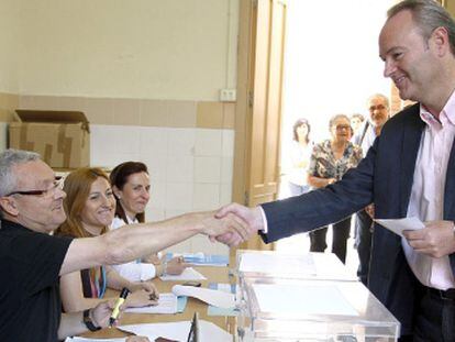 El alcalde de Castellón y candidato a la reelección, Alberto Fabra, saluda a los componentes de la mesa electoral.