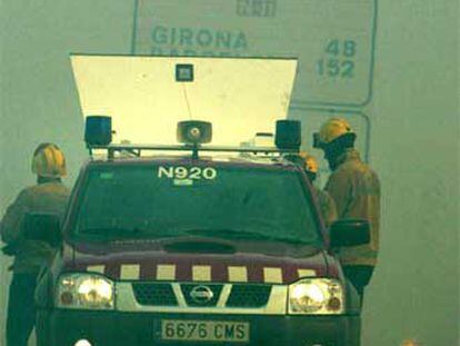Un coche de los Mossos d?Esquadra, en la N-II, que resultó cortada a causa del fuego.