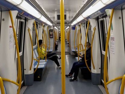 Dos viajeros en el metro de Madrid.