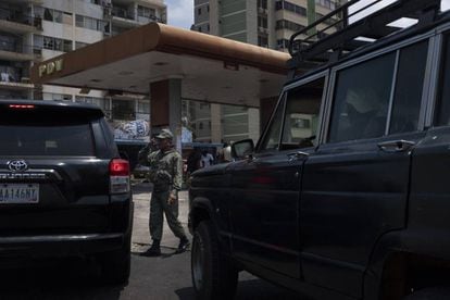 Un soldado saluda al conductor de una camioneta frente a una bomba de gasolina en Maracaibo.