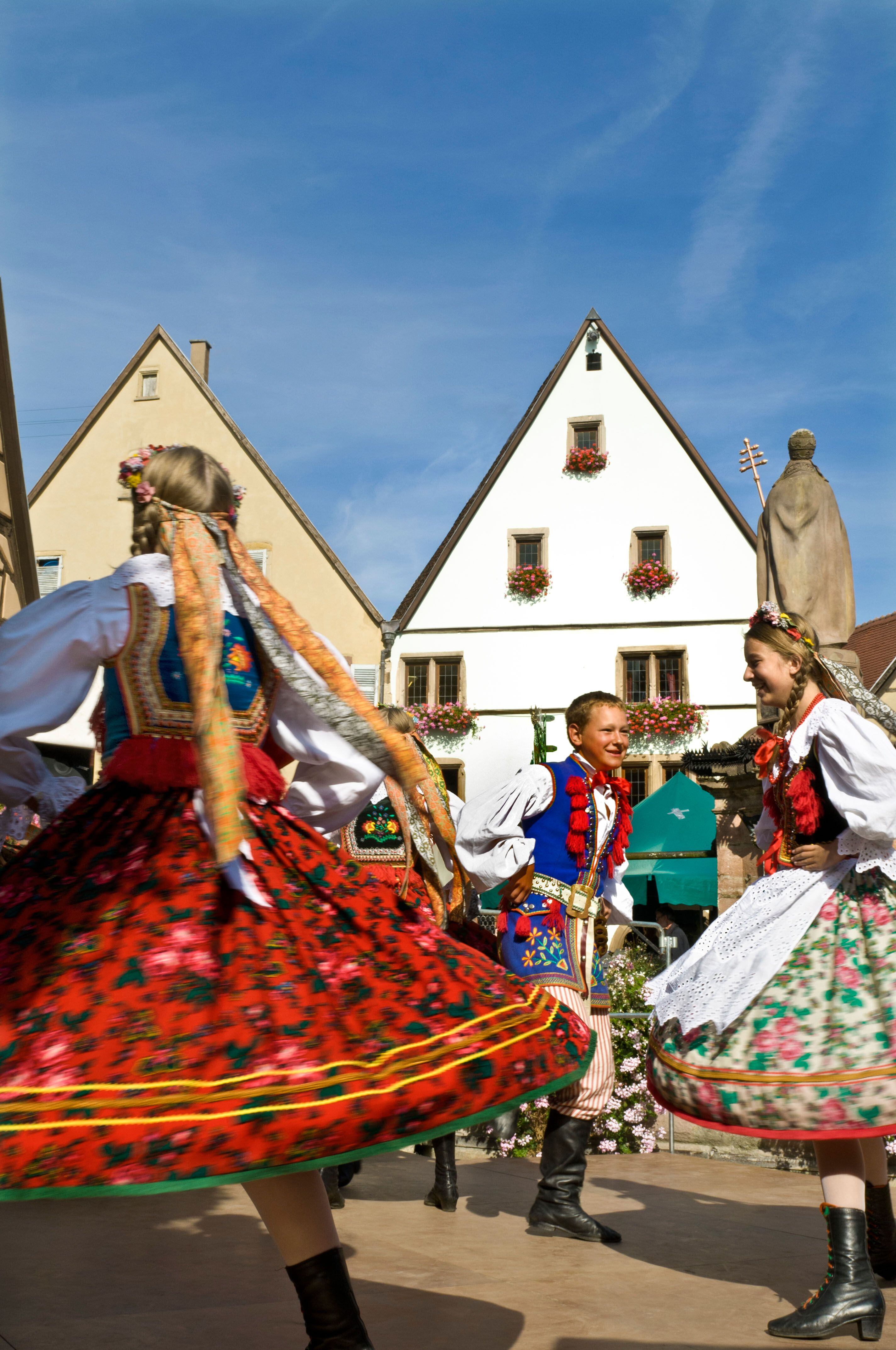 Jóvenes danzando con vestidos tradicionales durante la Fête du Vin Nouveau, la fiesta del vino nuevo en el pueblo de Eguisheim. 