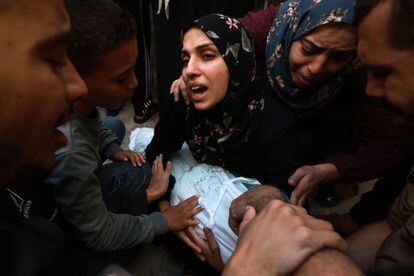 Una mujer se lamenta mientras sostiene el cuerpo de su hija asesinada, tras un ataque israelí, este viernes en Rafah.