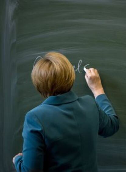 La canciller alemana, Angela Merkel, escribe su nombre en una pizarra en Berlín.