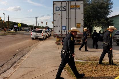 El alguacil del condado de Bexar, Javier Salazar, en el extremo derecho, y otros oficiales se alejan después de informar a los medios de comunicación en la escena donde se registró un camión de 18 ruedas en la cuadra 2000 de South General McMullen en San Antonio.