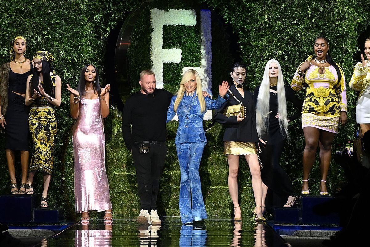Kim Jones y Donatella Versace saludando al final del desfile rodeados de algunas de las supermodelos.