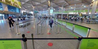 Interior del aeropuerto de Málaga con indicaciones de distancia de seguridad entre viajeros.