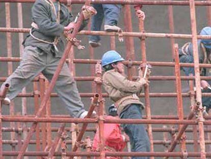 Trabajadores chinos montan una estructura metálica.