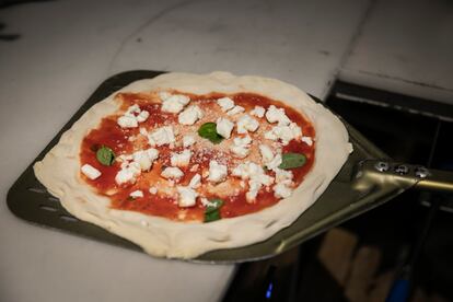 Una pizza preparata da cuocere nel forno a legna. 