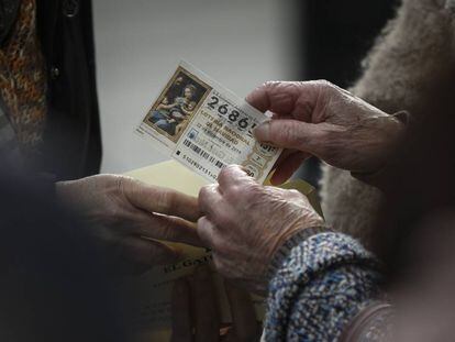 Un mujer guarda un décimo de lotería en un sobre en Sevilla.