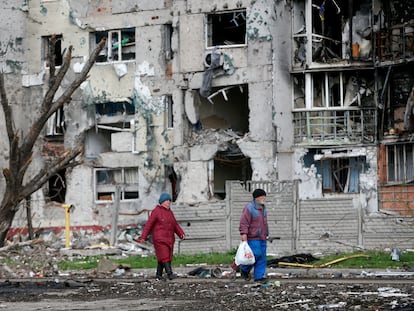 Dos personas pasan ante un edificio bombardeado en Mariupol, el día 22.