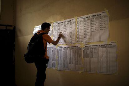 Un hombre busca este domingo su mesa electoral para emitir su voto en un colegio de Atenas.