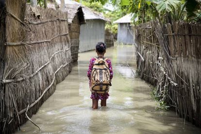 Una niña va al cole en su aldea inundada por lluvias torrenciales en Kurigram (Bangladés).