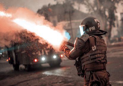 Un agente de la Policía chilena dispara su carabina lanza gases durante una protesta en 2019.