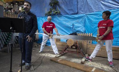 Hasier Larretxea (izquierda) recita un poema mientras sus padres, Patxi y Rosario, sierran un tronco, el 13 de noviembre en Barcelona.