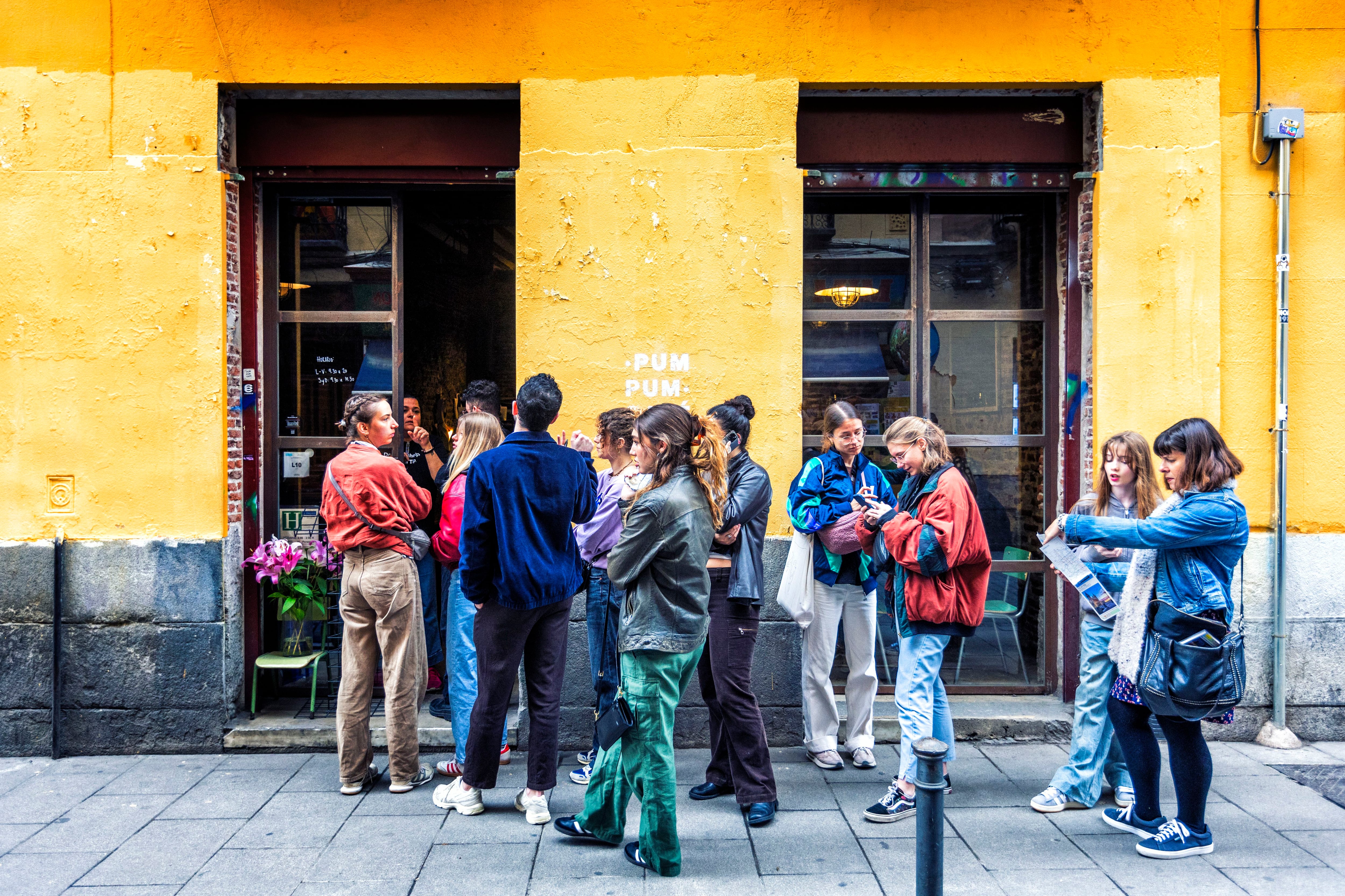 Varias personas hacen cola a la entrada de un nuevo local de desayunos en la calle Tribulete de Madrid.