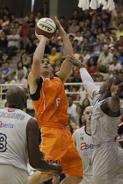 Los jugadores del Estudiantes, Flores y Simmons, bloquean el lanzamiento de Kirk Penney durante el XXVIII Torneo de la Comunidad de Madrid ACB.