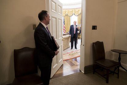 El Jefe de Gabinete Reince Priebus observa la Oficina Oval mientras el Presidente Donald Trump lee sus notas, el viernes 10 de marzo de 2017, antes de reunirse con el Liderazgo del Comité de Salud en la Casa Blanca.