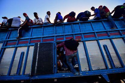 Migrantes de la caravana que se dirige de Honduras a Estados Unidos, abordan un camión en Metapa (México), el 22 de octubre de 2018. El presidente Donald Trump ha catalogado la caravana como una emergencia nacional.